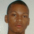Pixelated close-up of a person's face with short dark hair, light brown skin tone, and neutral expression against plain background.