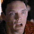 Static pixelated image of a person's face with light skin tone, visible eyes, nose, mouth, and partial hairline against dark background.