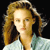 Pixelated image of a person with light brown hair styled in a side-swept manner, wearing a light-colored top with a greenish accent on the shoulder.