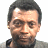 Pixelated image of a person with short dark hair and light skin, wearing a gray shirt against white background.