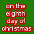 Green background with red text reading "on the eighth day of christmas my baby gave to me a pair of chloe shades and a diamond belly ring" and a pixelated image of a woman wearing a Santa hat.