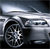 Pixelated silver sedan with visible front wheel and headlight, angled view against dark background.