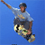 Pixelated static image of a person performing a skateboarding trick against solid blue background with visible dithering and color blending artifacts.