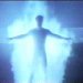 Pixelated blue-toned static image of a human silhouette with outstretched arms against a bright glowing background.