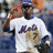 Pixelated image of a person in a white shirt with purple text, holding a baseball bat, next to orange text on a blue background.