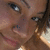 Pixelated close-up of a person's face showing eyes, nose, and mouth with brown skin tone and dark hair, cropped tightly around facial features.