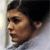 Pixelated profile view of a person with dark hair against a light background, showing partial facial features and ear.