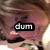 A close-up of a person's face with brown hair and closed eyes, overlaid by black text boxes containing the word 'dum' in various lengths.