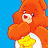 Pixelated Care Bears character with orange fur and yellow star emblem on white chest against blue background, next to "Care Bears" text and "B002 TOFC" code.
