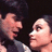 Pixelated image of two people in close proximity on a brown background with pink text elements.
