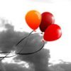 Three balloons in orange, dark red, and bright red float against a grayscale background with soft cloud-like shapes.