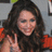A static pixelated image shows a person with long dark hair making a peace sign gesture, wearing red clothing against a gray background.