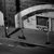 Black-and-white pixelated image of a stylized vehicle with a curved roof and rectangular windows, set against a dark background with vertical and horizontal lines.