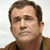 Static pixelated portrait of a man with short brown hair, light skin, and a brown jacket over a dark shirt against a light background.