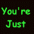 A static image of green pixelated text on a black dotted background with a gray rectangle in the bottom-right corner.