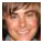 Pixelated static image of a person's face with indistinct features and warm-toned skin tones against a dark background.