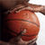 Static 50x50 pixel icon showing a close-up of a basketball with visible seams and texture, partially obscured by dark shapes on the left and right edges.