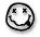 Black and white pixelated smiley face icon with thick black outline, two square eyes, and curved mouth on white background.