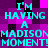 Pixelated cyan text repeats 'I'M HAVING A MADISON MOMENT!' across a purple and pink checkered background with black accents.