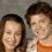 Two pixelated human faces in close proximity, one with long dark hair and the other with short brown hair against a muted gray background.