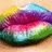 Pixelated image of a stylized fruit slice with layered colors including purple, pink, green, and blue against a light brown background.