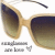 Pixelated image of a pair of sunglasses with light brown frames and dark gradient lenses, positioned against a white background.