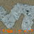 Pixelated silver paper cutouts of a dog-like figure on a brown background with orange text overlays.