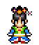 Pixel art character with black hair, colorful flower headpiece, green and blue outfit, red accents, standing pose on gray background.