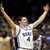 Pixelated static image of a basketball player in white jersey with arms raised against dark background, likely from early 2000s digital sports iconography.