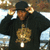 A person wearing a black hoodie and cap adjusts their hood with both hands, with text labels appearing below in different frames.