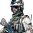 Pixelated figure in military-style camouflage uniform with helmet, holding a rifle, standing against white background.