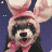 Pixelated cartoon icon of a dog wearing pink bunny ears and a red bow tie against a dark blue background with small cyan squares.