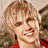 Pixelated close-up of a person with light brown curly hair wearing a red top, visible in a static image with no text or animation.