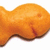 A pixelated orange fish-shaped cracker with a small red mark on its side, next to partial teal text reading "a Piran".