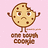 Pixelated cookie character with brown chocolate chips, arms raised, standing on a light pink background with brown text below.