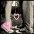 A static pixelated image shows a dark figure with pink heart symbols on its chest and lower body against a gray background.