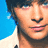 Pixelated image of a person with dark hair and blue eyes, wearing a white shirt against a blue background, with blue text overlays.
