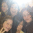 A pixelated static image shows four figures in a group pose with blurred facial features and indistinct clothing against a light background.