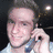 A pixelated image of a person holding a phone to their ear, with repeated blue text and heart symbols overlaid on the right side.