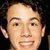 A person with dark curly hair and light skin appears in four -aligned , each showing a slightly different facial expression against a black background