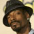 A pixelated close-up of a person wearing a dark wide-brimmed hat, with a light-colored background and visible facial features including a beard.