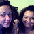 Two pixelated figures with dark hair and purple-toned skin stand side-by-side against a light green background, both smiling.