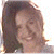 A pixelated image of a person with brown hair and light skin smiling, next to green text on a dark background.
