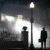 Two silhouetted figures stand under a streetlamp in a dark, foggy scene with bright light sources on the left and right.