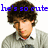 Pixelated image of a person with brown curly hair wearing a light gray sweater over a white collared shirt, with blue text overlays.