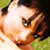 A pixelated close-up of a person's face with brown hair, brown eyes, and light skin, set against a green background.