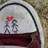 A pixelated image shows a white backpack with black trim, a red heart above two gray figures, and the text "i love you" in black below.