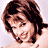 Pixelated image of a woman in white clothing with brown hair, smiling, showing partial body and arms in a with text overlay