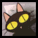 A black cat with yellow eyes lies on a gray surface, its head turning from left to right