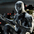A pixelated static image shows a dark, abstract figure with metallic silver and black tones, red accents, and a blurred background.